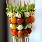 To make a great Caprese salad skewer, you need fresh ingredients. Here’s what you will need: - 20 cherry tomatoes, ripe and vibrant - 20 fresh basil leaves, whole - 20 small mozzarella balls (bocconcini), drained - 2 tablespoons balsamic glaze, for drizzling - 1 tablespoon extra virgin olive oil, for flavor - Sea salt and freshly ground black pepper, to taste - Skewers (7-inch or 10-inch), bamboo or metal These ingredients create a fresh and colorful dish. The sweet tomatoes, fragrant basil, and creamy mozzarella blend perfectly. To take your skewers up a notch, consider adding some extras: - Crushed red pepper flakes for a spicy kick - Pesto for a rich, herby flavor - Prosciutto slices for a savory touch These additions can make your dish more unique and exciting. Try mixing and matching to find your favorite flavor. Don’t have everything on hand? No worries! Here are some easy swaps: - Grape tomatoes instead of cherry tomatoes - Fresh mozzarella for pre-packaged mozzarella balls - Spinach leaves instead of basil These substitutes will still give you a tasty Caprese skewer. Feel free to get creative based on what you have. For the full recipe, check out the details above. To start, gather your skewers. If you have wooden skewers, soak them in water for about 10-15 minutes. This step stops them from burning. Next, wash your cherry tomatoes and fresh basil leaves under cold water. After rinsing, gently dry them with a paper towel. This ensures your ingredients are clean and ready. Now, it’s time to assemble the skewers. Grab a skewer and thread on a cherry tomato first. Then, add a fresh basil leaf on top of the tomato. Follow this with a mozzarella ball, making sure it fits snugly. Repeat this pattern two more times. You should have three sets of each ingredient on the skewer. Leave some space at both ends for easy handling. Once your skewers are ready, place them on a serving platter. Make them stand upright for a great look. Drizzle balsamic glaze over the skewers to add flavor and visual appeal. Next, add a drizzle of extra virgin olive oil. This adds richness to your dish. Finally, sprinkle sea salt and freshly ground black pepper to taste. If you want a little heat, add crushed red pepper flakes for a spicy kick. For the full recipe, check out Caprese Salad Skewers Delight. To make great Caprese salad skewers, start with fresh ingredients. Use ripe cherry tomatoes and soft mozzarella balls. Fresh basil leaves add aroma and taste. Soak wooden skewers in water for 15 minutes to prevent burning. This small step ensures your skewers hold up during cooking. When threading, alternate the ingredients. This creates a colorful and tasty mix. Aim for 3 sets of each item on the skewer. This balance gives each bite a burst of flavor. For a stunning display, stand the skewers upright in a tall glass. This adds height and interest to your table. You can also arrange them on a platter. Use fresh basil leaves as a garnish for extra flair. Drizzle balsamic glaze over the skewers for a glossy finish. Offer a small dish of extra glaze nearby for dipping. This invites guests to taste and enjoy. Creating a beautiful presentation enhances the experience of your Caprese salad skewers. Pair your skewers with the right flavors to enhance taste. A splash of balsamic glaze adds sweetness and tang. Extra virgin olive oil gives richness and depth to each bite. You can add a sprinkle of sea salt and freshly ground black pepper. These simple seasonings highlight the fresh flavors. For a spicy kick, try crushed red pepper flakes. This adds heat and excitement to the dish. Remember, the goal is to balance flavors for a delightful taste. {{image_4}} You can switch up the ingredients for your Caprese skewers. Try using different tomatoes, like grape or heirloom. For cheese, you can use feta or goat cheese. If you want a twist, add prosciutto or salami. You can also include olives or artichokes for more flavor. Caprese skewers fit many events. For a picnic, pack them in a container. For a fancy party, arrange them on a large platter. You can also serve them in small cups for easy grabbing. At a barbecue, place them on the grill for a smoky taste. Change the flavors with the seasons. In summer, use ripe tomatoes and fresh basil. In fall, add roasted squash or pumpkin. In winter, try using sun-dried tomatoes and arugula. In spring, fresh peas and radishes can add a nice crunch. These ideas keep your Caprese skewers fresh and exciting all year long. After enjoying your Caprese salad skewers, store any leftovers in an airtight container. This keeps them fresh for later. Refrigerate the container immediately. The skewers stay good for about 2 days. The longer they sit, the less fresh they become. To keep your ingredients fresh, store each item separately. Place cherry tomatoes in a cool, dry spot. Keep mozzarella balls in water or in a sealed bag. Store basil leaves in a glass of water on the counter. Cover the leaves with a plastic bag. This method helps them stay vibrant. You usually serve Caprese skewers cold. If you want to warm them, do it gently. Use a microwave for a few seconds. Avoid overheating, as this can ruin the flavors and textures. If you prefer, you can enjoy them straight from the fridge, too! Caprese salad skewers can last about two days in the fridge. Keep them in an airtight container. The tomatoes and cheese stay fresh longer this way. However, they taste best when eaten fresh. Yes, you can make Caprese skewers in advance. Prepare them a few hours before serving. They stay tasty for a short time, but the basil may wilt slightly. To keep them fresh, store them in the fridge until ready to serve. Serve Caprese salad skewers on a large platter. You can arrange them upright in a glass for a fun touch. Drizzle balsamic glaze over the skewers right before serving. Add a sprinkle of salt and pepper for extra flavor. For the full recipe, check out the ingredients and steps above. This dish is simple, fresh, and bursting with flavor! We explored how to make classic Caprese salad skewers. You learned about key ingredients, including optional ones for added flavor. I gave you step-by-step instructions for preparation and assembly, plus tips for perfecting your skewers. Variations let you customize your dish for any occasion. Finally, I shared storage tips to keep your leftovers fresh. Enjoy making these skewers, and have fun experimenting with flavors!